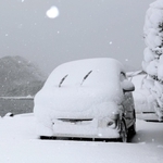 寒波の影響で降り出した雪に覆われた車＝２１日午前、豊岡市竹野町竹野（撮影・丸山桃奈）