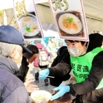 支援者から海鮮がゆを受け取る生活困窮者ら＝神戸市中央区加納町６、東遊園地
