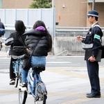 街頭に立って自転車の交通違反を取り締まる警察官たち＝２０２３年１２月中旬、尼崎市潮江