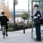 街頭に立って自転車の交通違反を取り締まる警察官たち＝２０２３年１２月中旬、尼崎市潮江