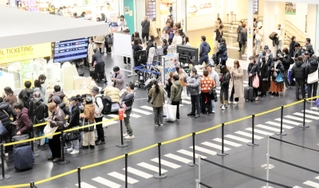 羽田空港の滑走路閉鎖を受け、搭乗キャンセルなどの手続きに並ぶ利用者ら＝神戸市中央区神戸空港、神戸空港
