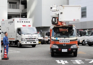 停電地域の復旧支援に向け、神戸を出発する関西電力送配電の作業車＝４日午後、神戸市中央区海岸通