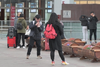 駅前で記念写真を撮る人たち＝８日午前、石川県金沢市のＪＲ金沢駅前（撮影・風斗雅博）