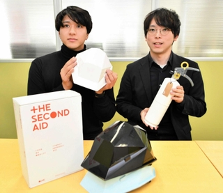ＬＩＦＥＧＩＦＴで扱う消火器を手にする泉勇作さん（右）ら＝東京都渋谷区