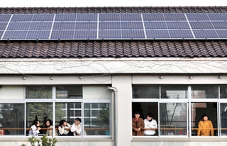 生徒たちがくつろぐ校舎の屋根に太陽光パネル。校内で使用する電気を賄う＝淡路市浜、ＡＩＥ国際高校（撮影・長嶺麻子）