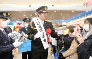一日通信指令官として啓発グッズを配る才木浩人投手＝神戸市中央区東川崎町１