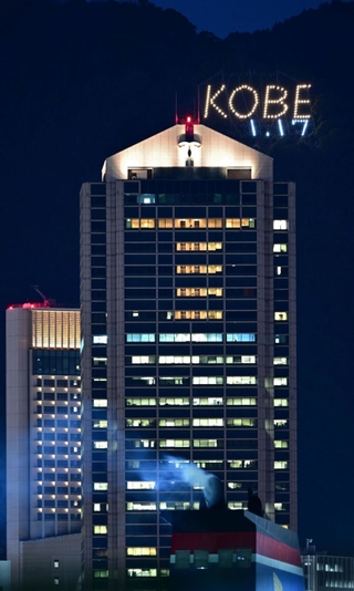 阪神・淡路大震災から２９年を前に、神戸の街に浮かび上がった「１・１７」の電飾。中央の建物は神戸市役所１号館＝１０日夜、神戸市中央区港島１から（撮影・中西幸大）