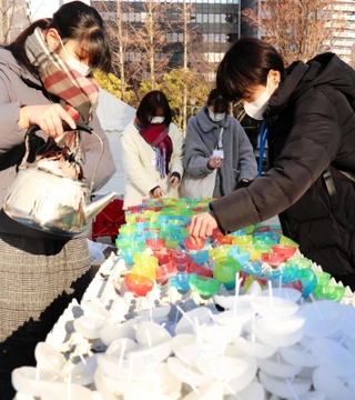 灯籠に使うろうそくを手作りするボランティアら＝神戸市中央区加納町６、東遊園地