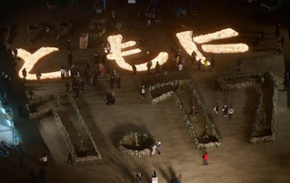 灯籠の火で浮かび上がった「ともに」の文字＝１６日午後６時２１分、神戸市中央区加納町６、東遊園地（撮影・中西幸大）