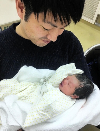 生まれたばかりの娘を抱く前田健太さん。父親になり、両親が注いでくれた愛情に気が付いた＝２０１８年（前田さん提供）