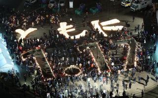 ろうそくの火で浮かび上がった「ともに　１・１７」の文字＝１７日午前５時１８分、神戸市中央区加納町６、東遊園地（撮影・中西大二）