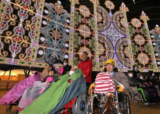 小雨が降る中、光の装飾を楽しむ人たち＝１８日夜、神戸市中央区加納町６（撮影・斎藤雅志）