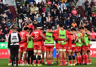 円陣を組み、観客とともに能登半島地震の犠牲者らに黙とうするラグビー神戸の選手＝１４日、神戸市兵庫区御崎町１