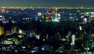 阪神・淡路大震災発生当夜の神戸・三宮。真ん中に光の全くない空間が広がる。その上に赤い明かりが見えるのは神戸市役所など。奥は大阪の街＝１９９５年１月１７日、ビーナスブリッジから