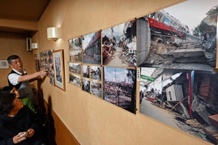 壁一面に張られた写真を前に、常連客と震災当時を振り返る陽山俊夫さん（左奥）＝神戸市東灘区御影石町２
