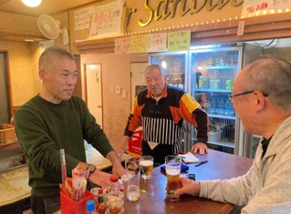 創業１００年に向けて。老舗角打ち店「ピアさんばし」の４代目、三橋優策さん（左）と父の敏弘さん（中央）＝神戸市兵庫区笠松通７