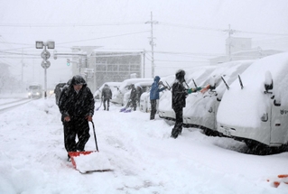 出勤後、駐車場の除雪に追われる人たち＝２４日午前、豊岡市寿町（撮影・阿部江利）