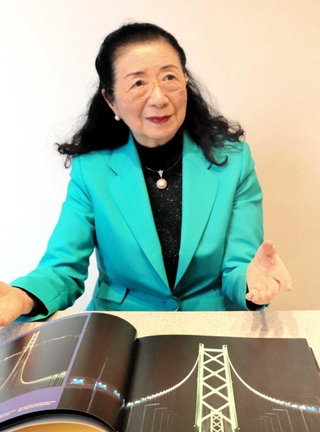 自ら手がけた明石海峡大橋のライトアップ写真を見ながら、思いを語る石井幹子さん＝東京都渋谷区