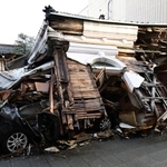 倒壊した家屋の下敷きになった車＝６日午前、石川県七尾市内（撮影・風斗雅博）