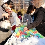 灯籠に使うろうそくを手作りするボランティアら＝神戸市中央区加納町６、東遊園地