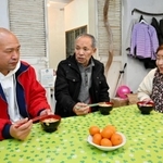 避難先で食卓を囲む大家勉さん（中央）と妻の美智子さん（右）、長男の真一さん＝淡路市下司
