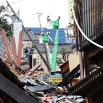 傾いた電柱の周囲で復旧作業が続いていた＝２１日午前、石川県輪島市（撮影・笠原次郎）