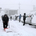 出勤後、駐車場の除雪に追われる人たち＝２４日午前、豊岡市寿町（撮影・阿部江利）