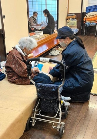石川県穴水町で被災者の話に耳を傾ける志茂千愛巡査長（右）＝１月16日（兵庫県警提供）