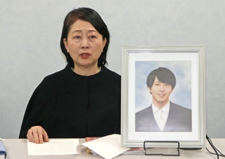 大阪地裁への提訴後、自殺した高島晨伍さんの遺影を前に記者会見する母の淳子さん＝２日午後、大阪市北区