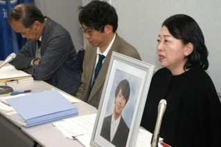 大阪地裁への提訴後、自殺した高島晨伍さんの遺影を前に記者会見する母の淳子さん（右端）ら＝２日午後、大阪市北区