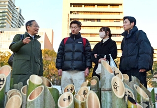 阪神・淡路大震災から２９年の追悼会場で、学生と話す村田昌彦さん（左）＝１月１７日、神戸市中央区加納町６、東遊園地（撮影・中西幸大）