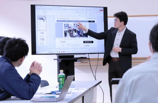 辰鼓楼の時計に関する情報サイトについて説明する兵庫県立大学の井関崇博教授＝いずれも豊岡市出石町内町