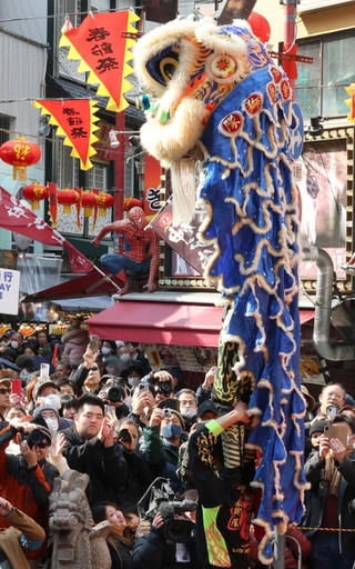 華麗な獅子舞に拍手を送る人たち＝１０日午前、神戸市中央区、南京町（撮影・笠原次郎）