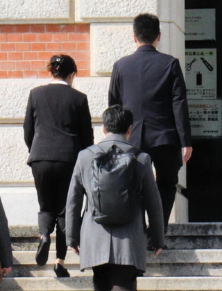 提訴するため、神戸地裁に入る遺族（中央奥２人）や弁護士たち＝神戸市中央区橘通２、神戸地裁