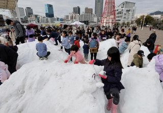兵庫県北部の香美町から運び込まれた雪で遊ぶ子どもたち＝１７日午前、神戸市中央区波止場町（撮影・長嶺麻子）