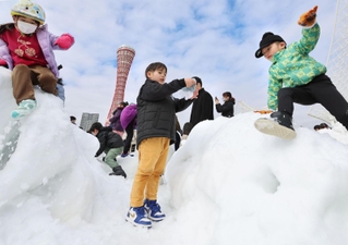 兵庫県北部の香美町から運び込まれた雪で遊ぶ子どもたち＝１７日午前、神戸市中央区波止場町２（撮影・長嶺麻子）