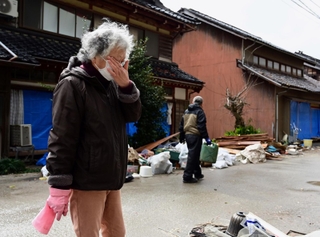 地震と津波で、自宅や仕事場が被害を受けた下谷真寿江さん。片付けのため避難先の金沢から通う。「まだ涙が出る」と顔を覆った＝２月２６日、石川県珠洲市三崎町（撮影・中西幸大）