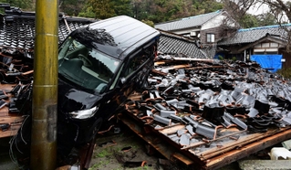 地震で崩れた寺の本堂と、津波で流されてきた車＝２月２５日、石川県珠洲市三崎町（撮影・中西幸大）