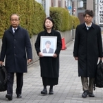 高島晨伍さんの遺影を手に大阪地裁に入る母の淳子さん（中央）ら＝２日午後、大阪市北区