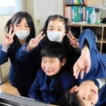 仲良しの友だちと学校生活を楽しむ垣内結都君（中央）。机の上には点字タイプライターが置かれている＝高砂市米田町塩市、米田西小学校