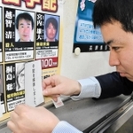 桐島聡容疑者の顔写真に「手配解除」の紙を貼り付ける兵庫県警の担当者＝２７日午後、兵庫県警本部