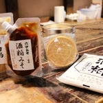 ヒット商品となった酒粕鍋みそ（左）や酒粕炭酸煎餅（中央）。右は販売用の酒粕＝神戸市東灘区