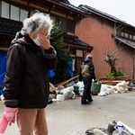 地震と津波で、自宅や仕事場が被害を受けた下谷真寿江さん。片付けのため避難先の金沢から通う。「まだ涙が出る」と顔を覆った＝２月２６日、石川県珠洲市三崎町（撮影・中西幸大）
