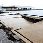 アスファルトがひび割れ、波打つ蛸島漁港の岸壁＝２月２５日、石川県珠洲市蛸島町（撮影・中西幸大）