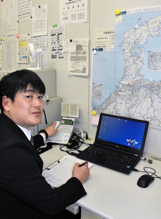 兵庫県警県民広報課で住民からの要望や苦情などに対応している葛西智広さん。壁には能登半島の地図が張り出されている＝神戸市中央区、県警本部