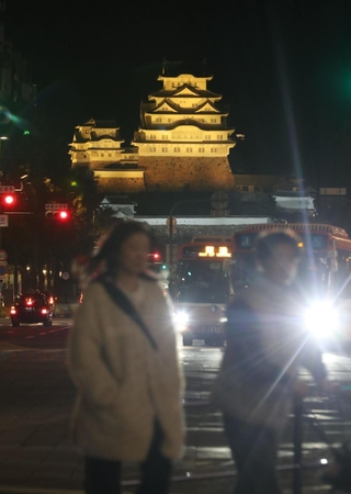 「国際女性デー」でミモザカラーにライトアップされた国宝姫路城＝８日夜、姫路市駅前町から（撮影・辰巳直之）