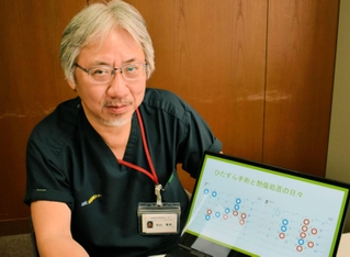 ２人の重症熱傷患者の治療に追われた日々を振り返る松山重成さん。パソコン画面の赤丸は京アニ事件の被害女性の手術日、青丸は事件前から入院していた男性患者の手術日を表す＝神戸市中央区脇浜海岸通１、兵庫県災害医療センター