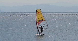 ウインドサーフィンをする人の姿も。空気は冷たいが、光は春の日差しだ＝１０日午前、神戸市須磨区の須磨海岸（撮影・風斗雅博）