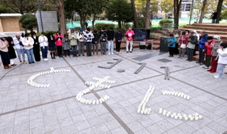東日本大震災の発生時刻に合わせ、神戸で開かれた追悼行事。ろうそくで「３．11　ともに」の文字を書いた＝１１日午後２時４６分、神戸市中央区加納町６（撮影・小林良多）