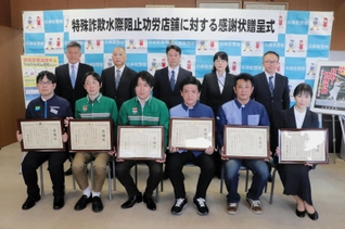 蓮井賢一生活安全部長（後列中央）から感謝状を受け取った「功労店舗」のオーナーら（前列）＝兵庫県警本部